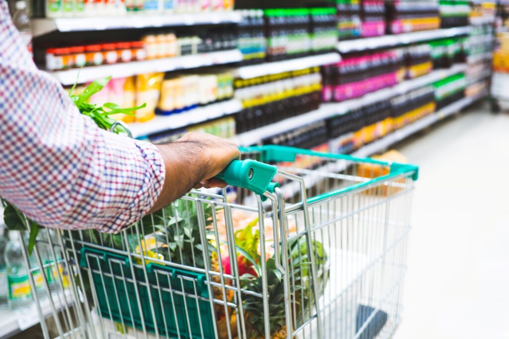 Hand pushing grocery cart in store